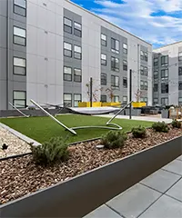 Courtyard with hammocks, bistro lights, lounge seating, lush landscaping, and fire pit