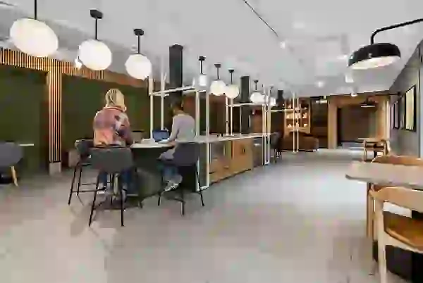 Social co-working lounge with group seating, fireplace, mini-fridge, and lounge